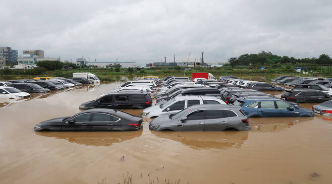 많은 비가 내린 30일 경기도 수원시의 한 중고차 단지 주차장이 물에 잠겨 있다.   연합뉴스
