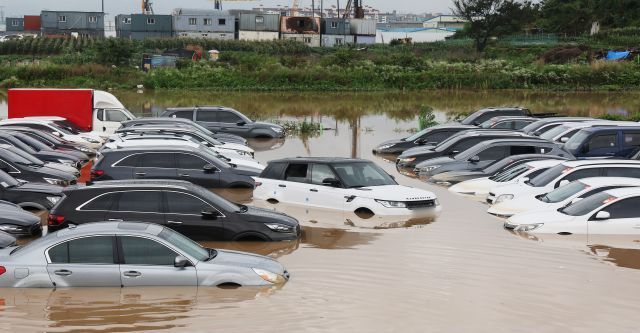 - 많은 비가 내린 30일 경기도 수원시의 한 중고차 단지 주차장이 물에 잠겨 있다. 연합뉴스