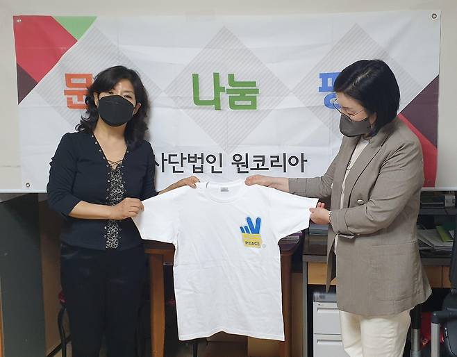김희정 이사장(왼쪽)이 평화 티셔츠를 선보이는 장면 [원코리아 제공]