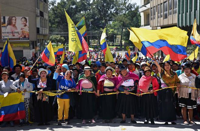 지난달 30일(현지 시각) 에콰도르 수도 키토 중심가에서 원주민들이 주축이 된 시위대가 깃발을 흔들고 행진하며 정부에 기름값 폭등 문제 해결을 요구하고 있다. 일부 지역에서 산발적으로 시작된 이 시위는 순식간에 전국적인 규모로 확산했고 정부는 국가비상사태를 선포했다. 이날 천주교계가 중재한 협상에서 원주민단체들이 에콰도르 정부가 내놓은 대책을 수용하면서 시위는 18일 만에 종료됐다./ AFP연합뉴스