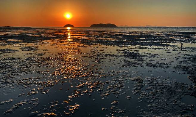 The sun sets over the Sojukdo (left) and Daejukdo in the West Sea off the Gochang Getbol Tidal Flats, which are listed on the UNESCO World Heritage convention for exhibiting a complex combination of geological, oceanographic and climatologic coastal diverse sedimentary systems. Photo © Hyungwon Kang　