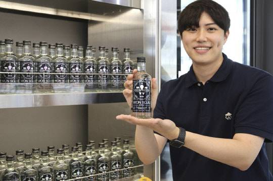 모델이 원소주 스피릿 상품을 들고 포즈를 취하고 있다. <GS25 제공>