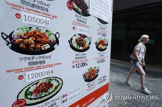 서울 중구 명동의 한 식당 배너에 인상된 가격표가 덧붙여져 있다. [연합뉴스 자료사진]