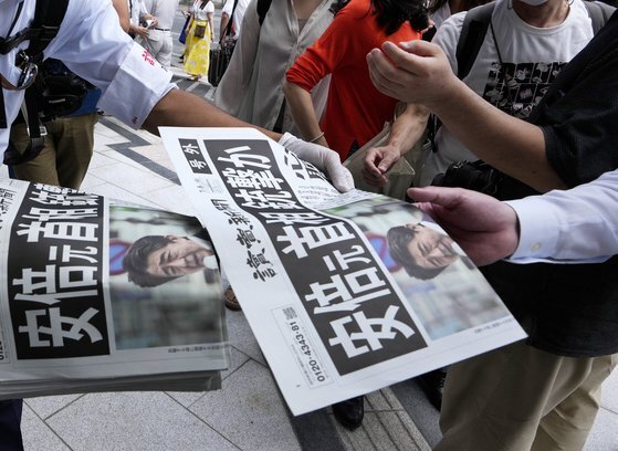 8일 오전 일본 도쿄에서 시민들이 아베 전 총리 피습 소식이 담긴 호외를 읽고 있다. [EPA=연합뉴스]