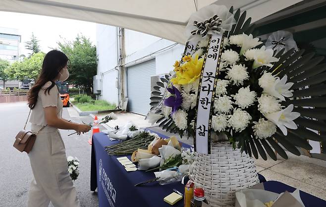 인하대학교 캠퍼스에서 같은 학교 재학생을 성폭행한 뒤 건물에서 추락해 숨지게 한 사건이 발생한 가운데 17일 오전 인천광역시 인하로 인하대학교에 마련된 추모공간에서 한 학생이 헌화를 하고 있다. /뉴스1