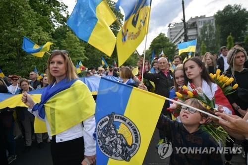 폴란드에 감사하는 우크라이나 난민 폴란드로 들어온 우크라이나 난민들이 지난 5월 29일 바르샤바에서 난민들을 받아준 폴란드 정부에 감사를 표시하는 가두시위를 벌이는 모습. [EPA 제공. 재판매 및 DB 금지]