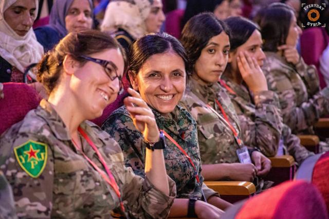 21일 시리아 쿠르드족 여권운동 단체들이 쿠르드족 자치 10주년 기념으로 기획한 ‘여성혁명포럼’에서 쿠르드족 여성 전사들과 참석자들이 환하게 웃고 있다. 로자바정보센터 제공