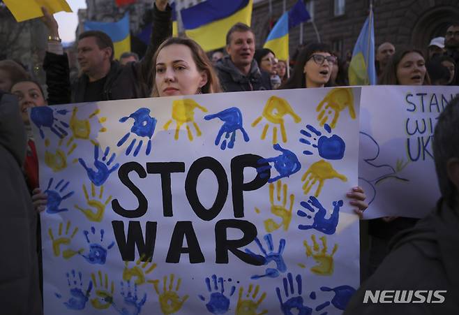 [소피아=AP/뉴시스] 24일(현지시간) 불가리아 수도 소피아에서 러시아의 우크라이나 침공에 반대하는 대규모 시위가 열려 한 여성이 "전쟁을 멈춰라"라고 쓰인 손팻말을 들고 우크라이나인들과 연대하고 있다. 이 시위는 볼로디미르 젤렌스키 우크라이나 대통령이 러시아의 침공 한 달을 맞아 전 세계 사람들에게 반전 시위를 촉구한 데 따른 것이다. 2022.03.25.