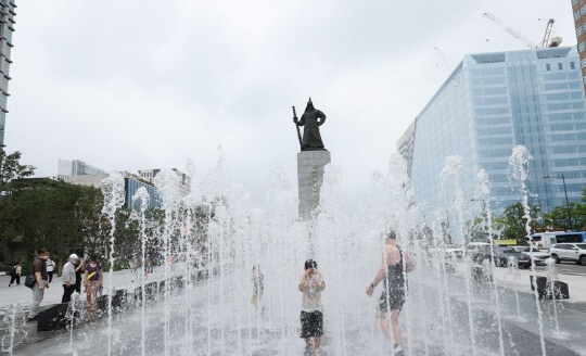 서울 광화문광장이 개장한 6일 오전 어린이 등이 분수대에서 더위를 식히고 있다. 사진=연합뉴스