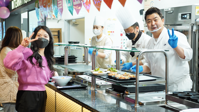 삼성웰스토리는 스타셰프가 직접 사내식당을 찾아 자신만의 메뉴를 직장인들에게 선보이는 '셀럽테이블'을 선보이고 있다. 사진은 4월 경기 안양시 한 게임회사 구내식당에서 셀럽테이블에 참여한 정호영 셰프가 배식 중 기념 촬영을 하는 모습. 삼성웰스토리 제공
