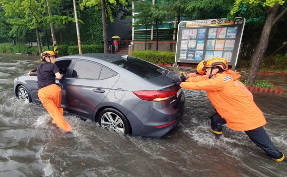 폭우가 내린 8일 인천시 미추홀구 용현동의 한 거리에 차량이 침수돼 소방대원들이 안전조치를 하고 있다. (인천소방본부 제공)