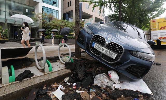 서울을 비롯한 중부지역에 기록적인 폭우가 내린 9일 오전 서울 서초구 진흥아파트 앞 서초대로에 전날 쏟아진 폭우에 침수, 고립된 차량이 인도 자전거거치대에 올라와 있다. 뉴스1