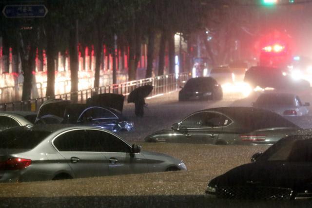 서울과 경기남부 등 수도권에 폭우가 내린 8일 오후 서울 강남구 일대 도로가 침수돼 차량이 잠겨 있다. 뉴시스