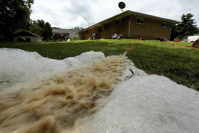 지난 4일(현지시간) 미 미주리주 일부 지역에 밤새 내린 폭우로 홍수가 발생해 제퍼슨 카운티의 한 주민이 펌프로 지하실 물을 빼내고 있다. 이 주민은 "침실이 지하에 있는데 모든 게 다 젖었다"라고 하소연했다. 제퍼슨 카운티=AP뉴시스