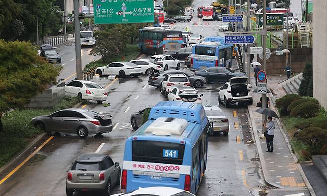 9일 서울 서초구 진흥아파트 앞 서초대로 일대에서 전날 내린 폭우에 침수됐던 차량이 모습을 드러내고 있다. 연합뉴스