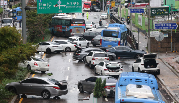 - 9일 오전 서울 서초구 진흥아파트 앞 서초대로 일대에서 전날 내린 폭우에 침수됐던 차량이 모습을 드러내고 있다. 2022.8.9 연합뉴스