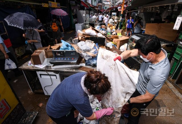 10일 서울 동작구 남성사계시장 입구에서 상인들이 복구 작업을 하고 있다.