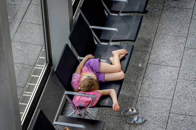 독일 프랑크푸르트 국제공항 로비에서 잠에 빠진 어린 소녀의 모습.