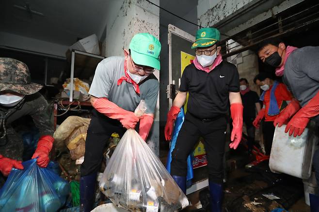주호영 국민의힘 비상대책위원장과 권성동 원내대표가 11일 폭우 피해를 입은 서울 동작구 사당동의 한 빌딩 지하에서 수해 복구 자원봉사를 하고 있다. /뉴스1