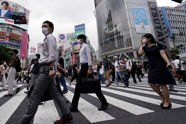 마스크를 쓴 행인들이 일본 도쿄의 중심가 시부야 거리의 횡단보도는 건너가고 있다.