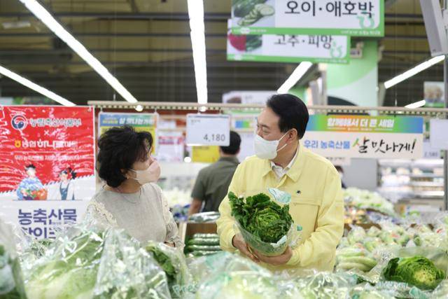 물가 점검에 나선 윤석열 대통령이 11일 서울 서초구 하나로마트 양재점에서 채소 코너를 살펴보며 한 시민과 대화하고 있다. 대통령실 제공