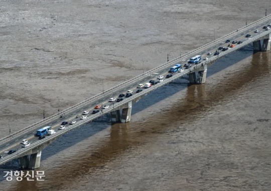 Muddy Water Up to Right Below the Bridge: On August 10, the water level of Hangang River, muddy due to the downpour in the Seoul metropolitan area, rose, and a view from the 63 Sky Art Gallery in Yeouido, Seoul shows cars on Wonhyo Bridge slowly heading to work. Seong Dong-hun