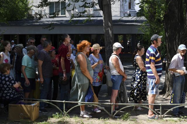 9일(현지시간) 우크라이나 자포리자에 있는 인도적 구호물자 배급소에서 주민들이 음식을 받기 위해 줄을 서서 기다리고 있다. AP연합뉴스