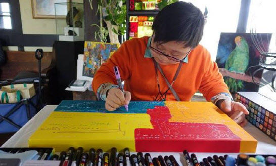다운증후군 장애를 가진 김현우 작가가 ‘수학드로잉’ 작품 시리즈를 작업하고 있는 모습(사진=뉴스1).