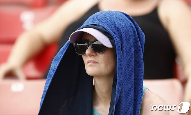 영국 잉글랜드 중부 레스터에서 한 여성이 더위를 피하기 위해 모자와 수건으로 얼굴을 가리고 크리켓 경기를 관람하고 있다. 2022.07.18 ⓒ 로이터=뉴스1 ⓒ News1 정윤미 기자