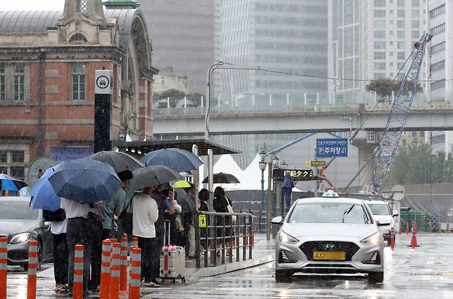 수도권 등 중부지방을 중심으로 많은 비가 내린 9일 서울 중구 서울역 택시 정류장에 시민들이 길게 줄을 선 채 택시를 기다리고 있다. /뉴스1