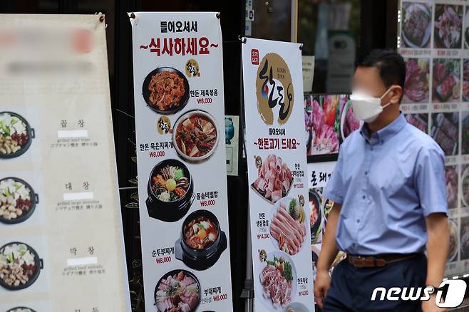 서울 시내 한 거리에서 시민들이 마스크를 착용한 채 식당 메뉴 알림판 앞을 지나고 있다. 2022.7.25/뉴스1 ⓒ News1 조태형 기자