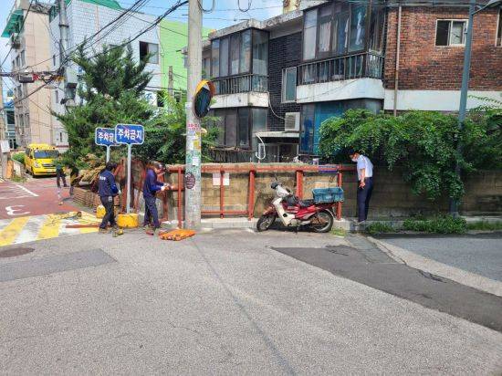 ‘찾아가는 건축상담서비스‘ 시범 운영을 하며 붕괴 위험이 있는 담장에 임시 보수를 진행하고 있다.