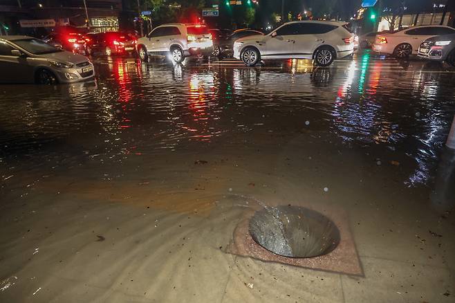 지난 9일 새벽 폭우로 서울 강남구 대치사거리의 배수구가 뚜껑이 없어진 채 소용돌이치고 있다. 연합뉴스 제공