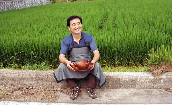 김우희 목수가 지난 3일 경남 창원시 마산합포구 진동면의 작업실 목우공방 옆 논두렁에 앉아 작업을 설명하고 있다. 한옥 대목장을 15년 하던 그는 2016년부터 제2의 고향인 진동면에 내려와 소목장으로 산다.