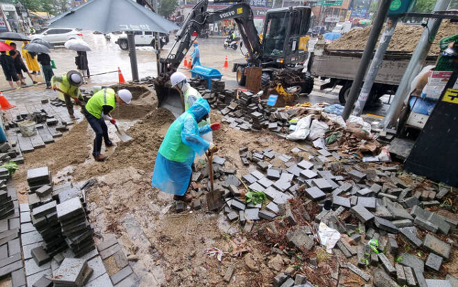 침수차량으로 뒤엉킨 도로 지난 9일 오전 신대방역 일대가 지난밤 폭우로 피해를 입은 가운데 관계자들이 복구 작업을 하고  있다. [사진 = 이승환 기자]