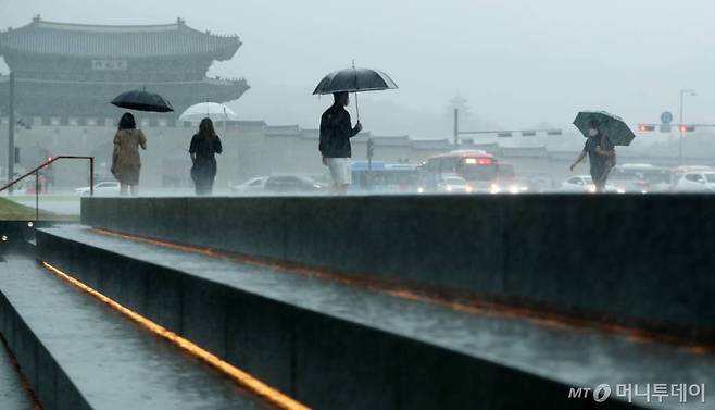 서울 등 수도권 대부분 지역에 호우경보가 내려진 지난 8일 서울 광화문광장에서 시민들이 발걸음을 옮기고 있다./사진=김휘선 기자 hwijpg@