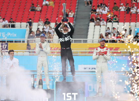 Edoardo Mortara , center, Stoffel Vandoorne , left, and Jake Dennis celebrate on the podium at the end of the second race of the Hana Bank Seoul E-Prix in Jamsil, southern Seoul on Sunday.  [YONHAP]