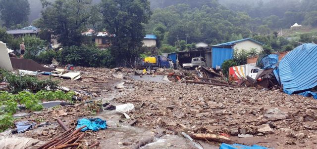 충남 부여 은산면의 한 마을이 14일 오전 산에서 흘러내린 토사에 뒤덮여 있다. 연합뉴스