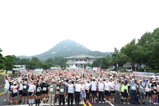 참가자들이 용산을 향해 출발하기 전 청와대 앞에서 손을 흔들고 있다. 연합뉴스
