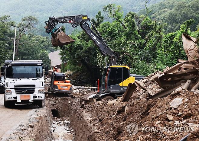 휴일에도 계속되는 복구작업 (여주=연합뉴스) 홍기원 기자 = 지난 집중호우 때 산사태가 발생했던 경기도 여주시 산북면 명품리 마을에서 14일 오후 중장비를 이용한 복구작업이 진행되고 있다. 2022.8.14 xanadu@yna.co.kr