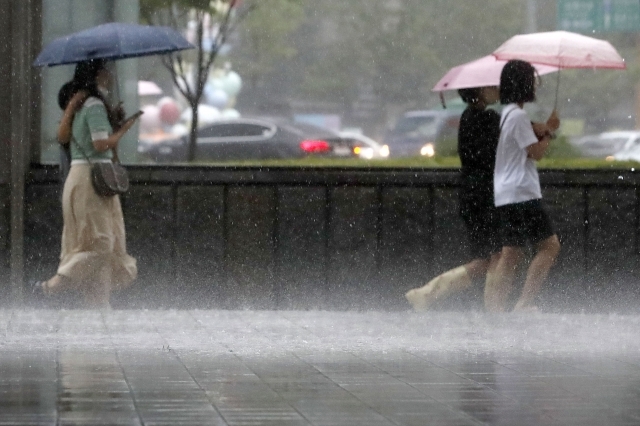 중부 지방에 호우특보가 발효된 지난 8일 서울 을지로입구역 인근에서 시민들이 쏟아지는 비를 피해 발걸음을 재촉하고 있다. 뉴시스