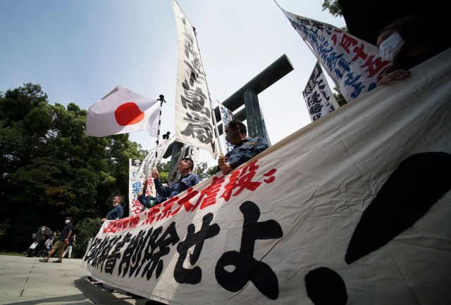 일본 극우단체 회원들이 15일 도쿄 야스쿠니신사에서 제국주의 시절 전쟁범죄자를 찬양하는 내용의 현수막을 펼치고 있다. AFP연합뉴스