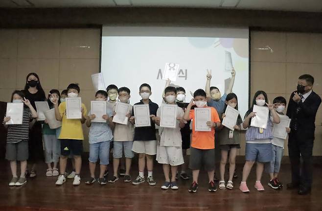 서울교대 인공지능교육연구센터와 함께하는 손쉽게 배우는 데이터과학 여름방학 캠프에 참여한 초등학생 3~4학년 B반 학생이 수료증을 받고 기념촬영을 하고 있다.