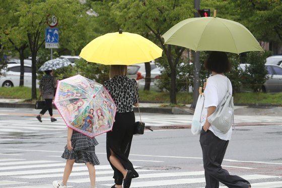 광주와 전남에 호우주의보가 발효된 16일 오전 광주 서구 치평동에서 한 시민들이 우산을 쓰고 걷고 있다. 연합뉴스