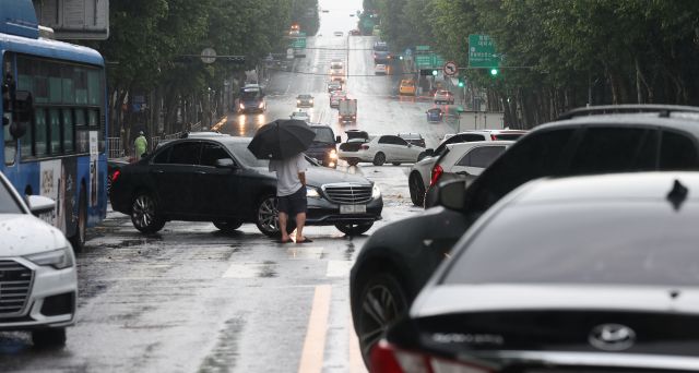 중부지방 집중호우 이튿날인 9일 오전 서울 강남구 대치역 인근 도로에 폭우로 침수된 차들이 방치돼 있다. 연합뉴스