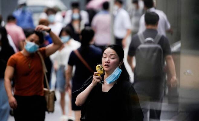중국을 강타한 기록적 폭염에 손 선풍기로 더위를 식히고 있는 현지 시민 /로이터=뉴스1