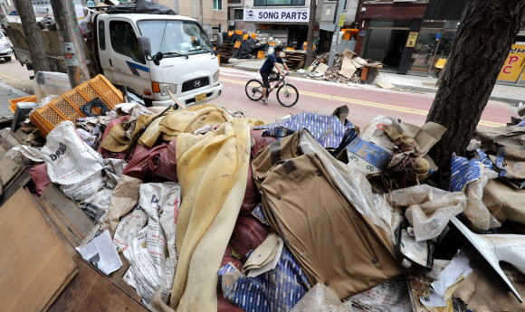 15일 서울 관악구 신사시장 인근 점포 앞 도로에 침수 폐기물들이 쌓여있다.연합뉴스