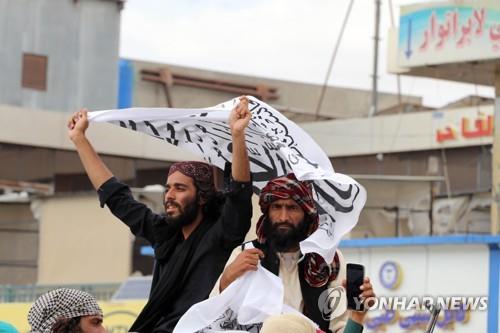 아프간 칸다하르에서 탈레반 상징 깃발을 흔들며 집권 1년을 축하하는 이들. [EPA 연합뉴스 자료사진. 재판매 및 DB 금지]