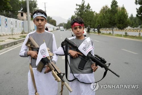 총을 들고 탈레반 집권 1년을 축하하는 아프간 소년. [AP 연합뉴스 자료사진. 재판매 및 DB 금지]