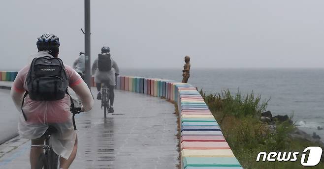 제주시 용담해안도로에서 비옷을 입은 사람들이 자전거를 타고 있다(뉴스1DB) ⓒ News1 오현지 기자